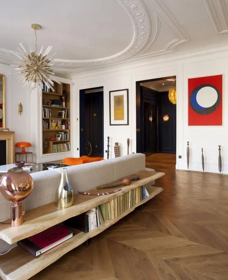 Light grey couch placed in the middle of a room with wooden floors.