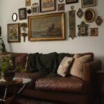 Brown leather sofa beneath a gallery wall of eclectic framed art and mirrors.