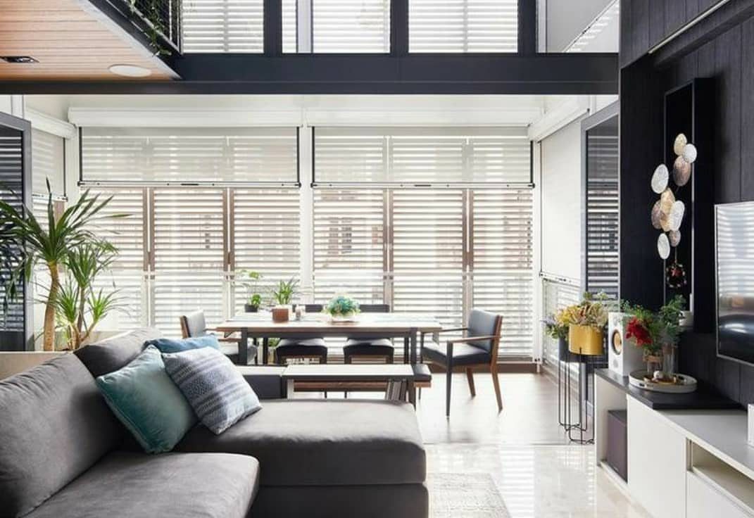 Grey sectional sofa and dining area in a bright, modern open-concept living room.