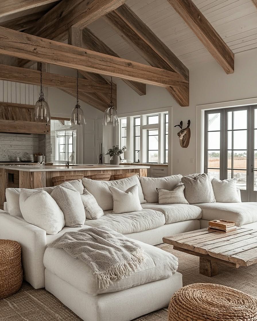 White sectional sofa and rustic wooden coffee table under exposed ceiling beams.