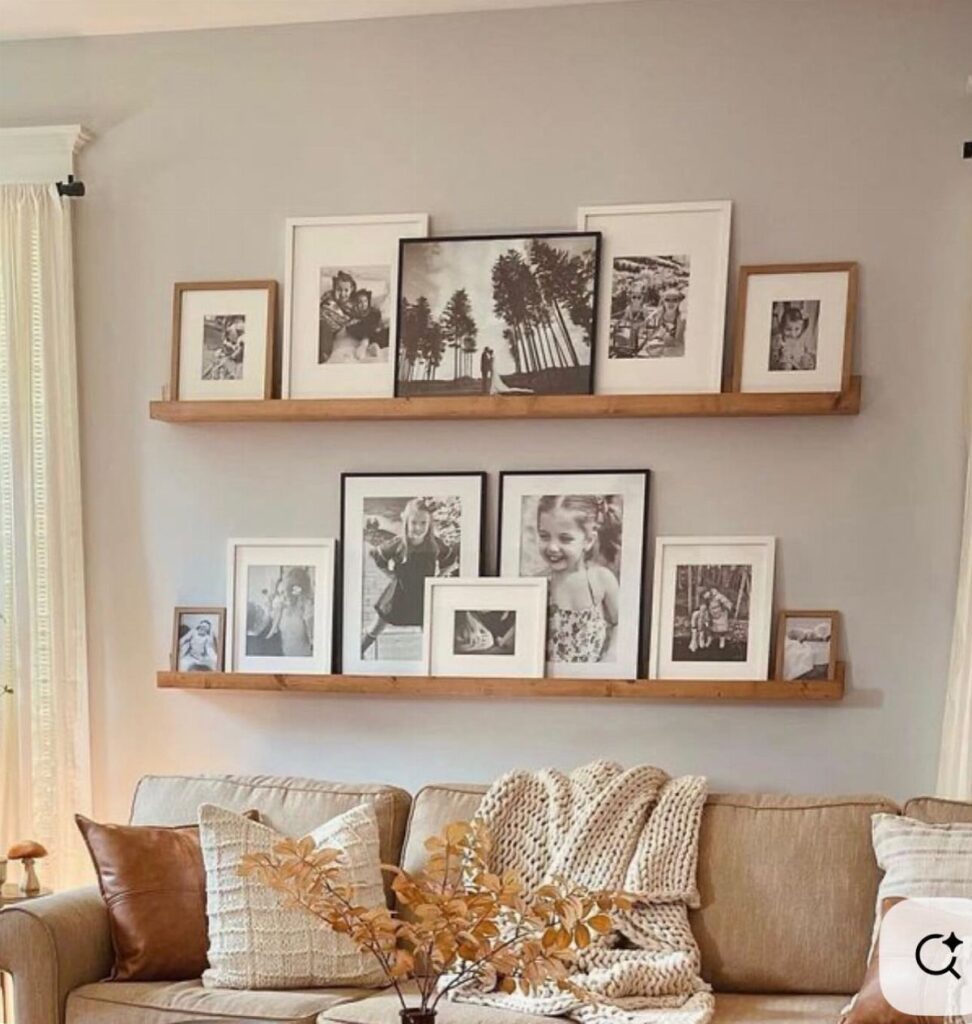 Two wooden picture ledges with black and white photos above a beige couch